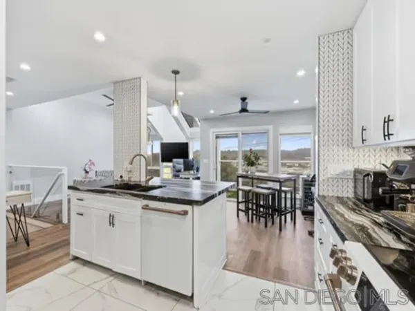 a kitchen with lots of counter and chairs