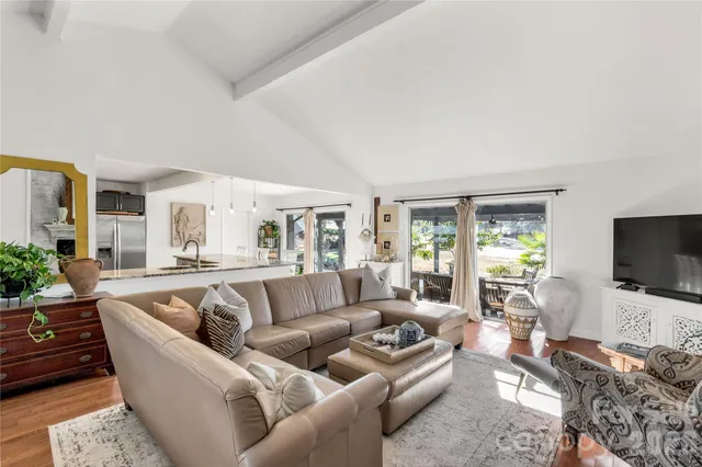 a living room with furniture flat screen tv and a large window