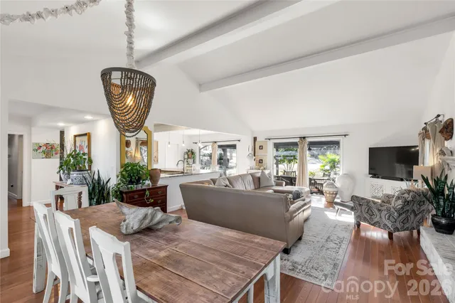 a living room with furniture a flat screen tv and a large window