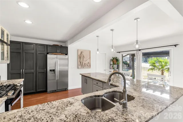 a kitchen with stainless steel appliances granite countertop a sink a stove and a refrigerator