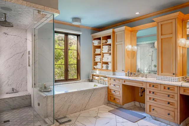 a spacious bathroom with a double vanity sink large mirror and a bathtub