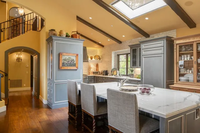 a dining hall with stainless steel appliances granite countertop a dining table and chairs with wooden floor