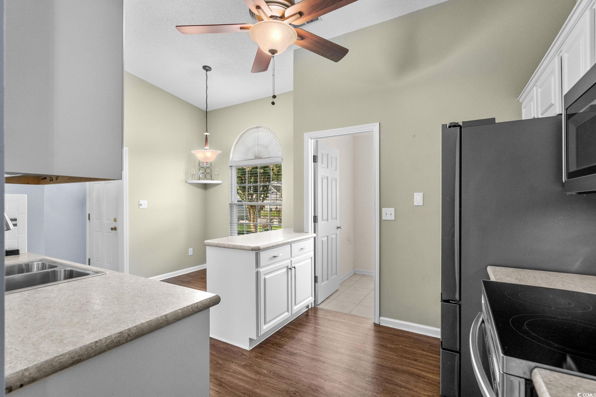 9568 Indigo Club Drive Murrells Inlet, SC 29576 - Photo 12 of 40 Kitchen with white cabinets, light countertops, dark wood-type flooring, and appliances with stainless steel finishes