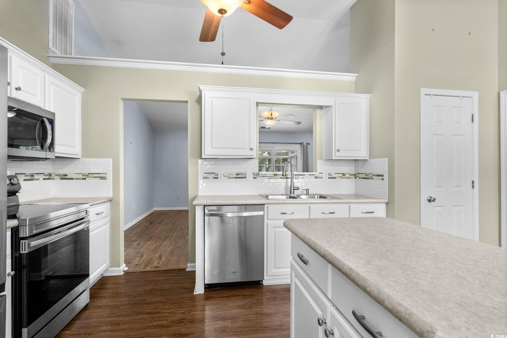 9568 Indigo Club Drive Murrells Inlet, SC 29576 - Photo 19 of 40 Kitchen with ceiling fan, stainless steel appliances, and white cabinetry