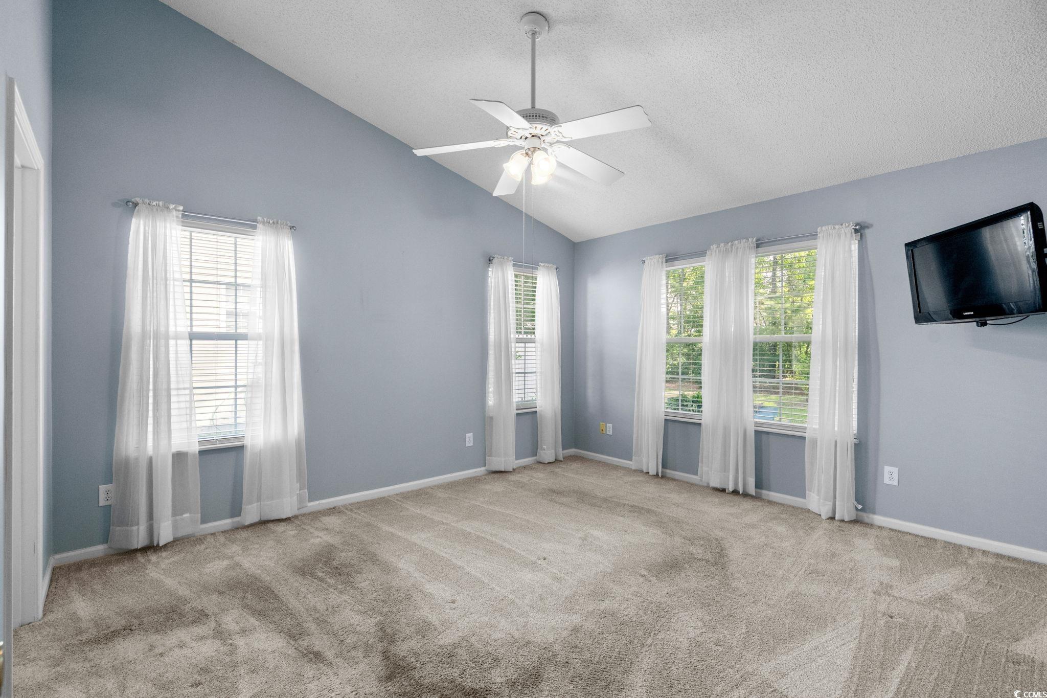 9568 Indigo Club Drive Murrells Inlet, SC 29576 - Photo 21 of 40 Spare room featuring lofted ceiling, light carpet, a ceiling fan, and a textured ceiling