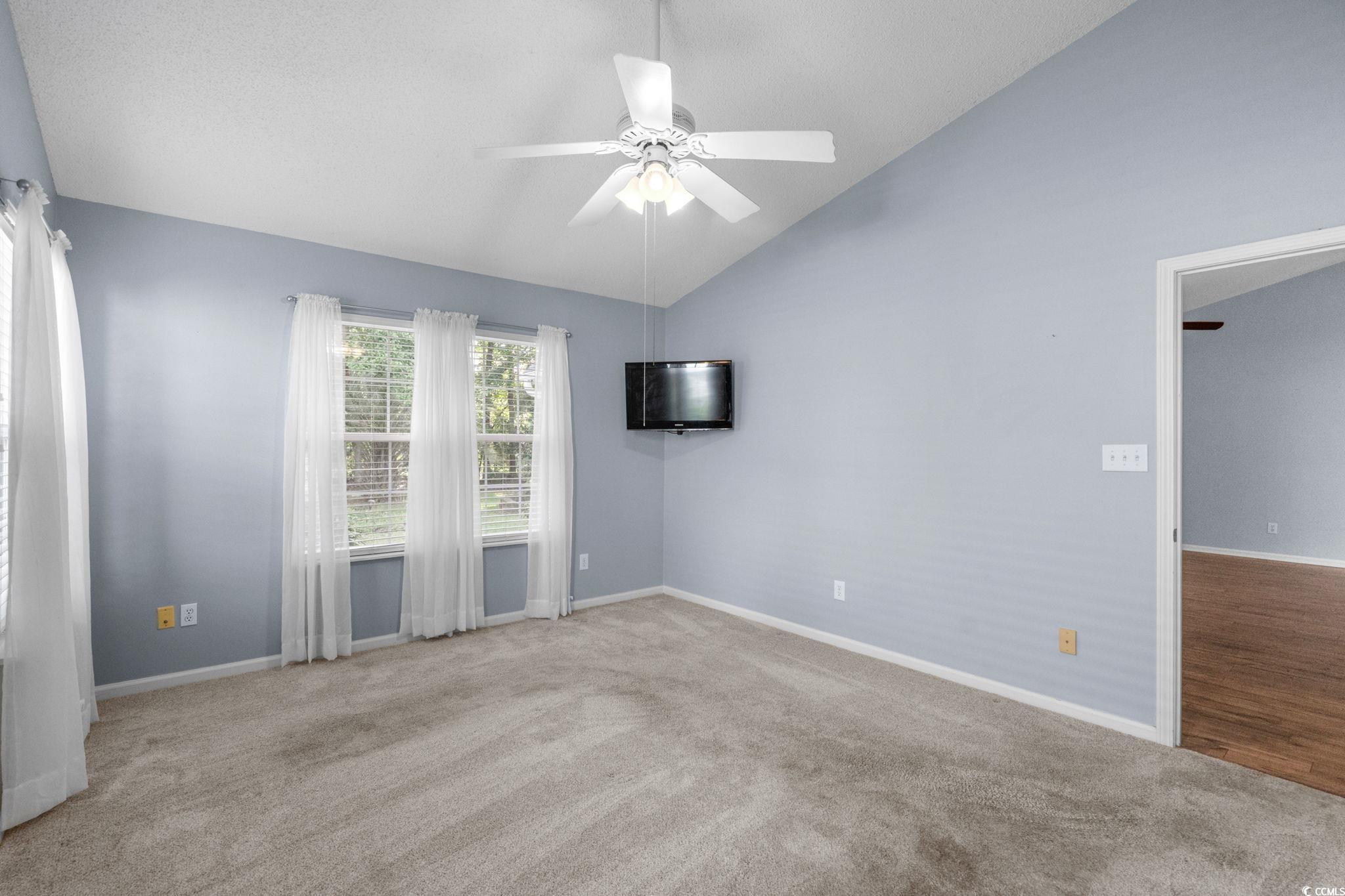 9568 Indigo Club Drive Murrells Inlet, SC 29576 - Photo 22 of 40 Empty room featuring light colored carpet, ceiling fan, and high vaulted ceiling
