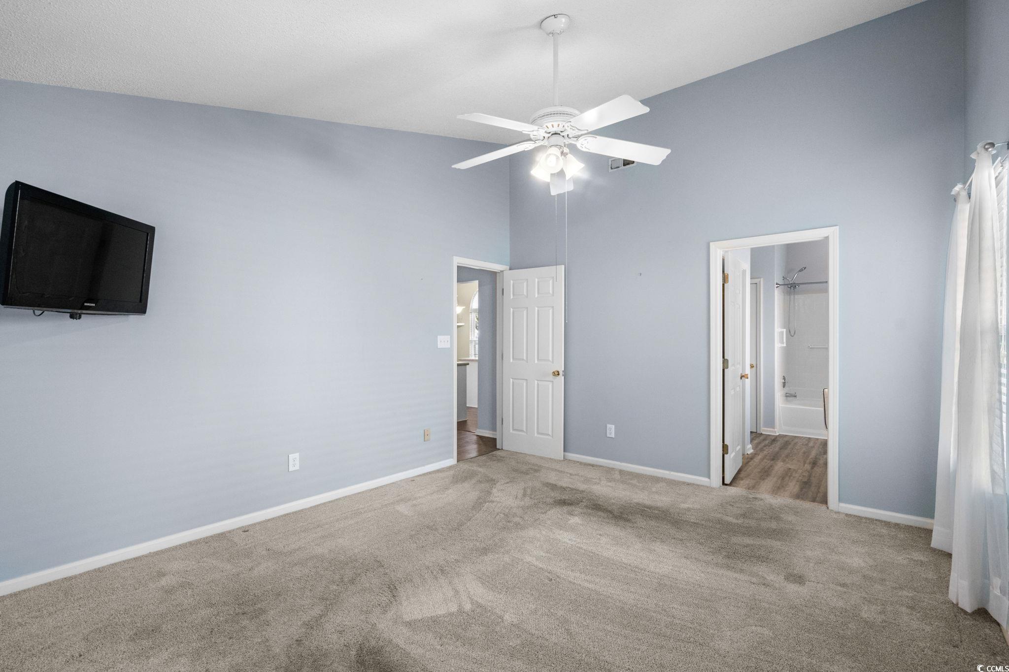 9568 Indigo Club Drive Murrells Inlet, SC 29576 - Photo 23 of 40 Unfurnished bedroom featuring high vaulted ceiling, carpet, a ceiling fan, and ensuite bath