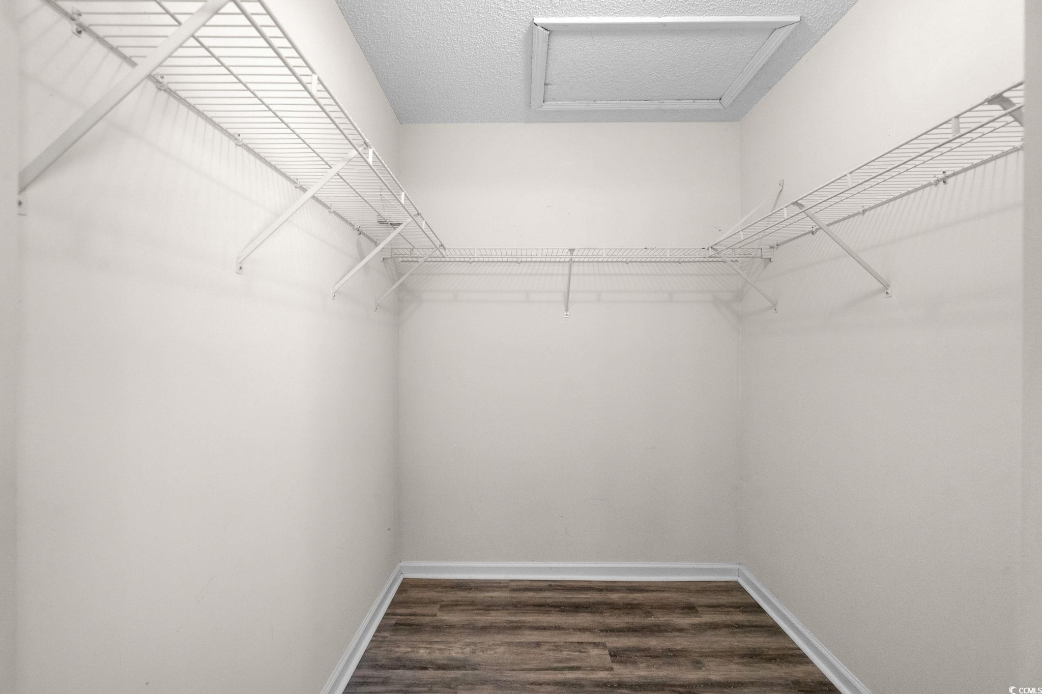 9568 Indigo Club Drive Murrells Inlet, SC 29576 - Photo 25 of 40 Walk in closet with dark wood-type flooring and attic access