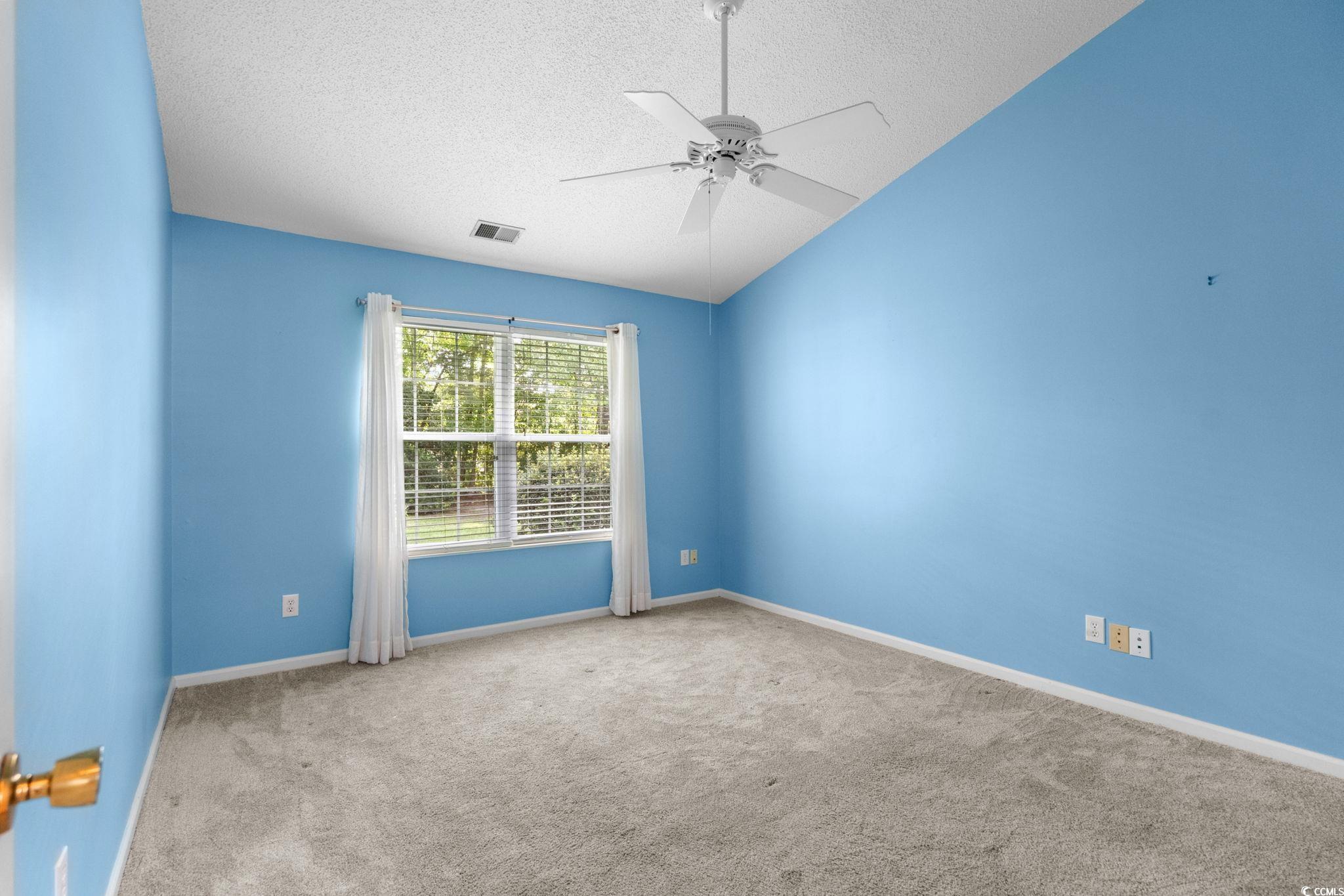 9568 Indigo Club Drive Murrells Inlet, SC 29576 - Photo 26 of 40 Spare room with a textured ceiling, carpet flooring, vaulted ceiling, and a ceiling fan