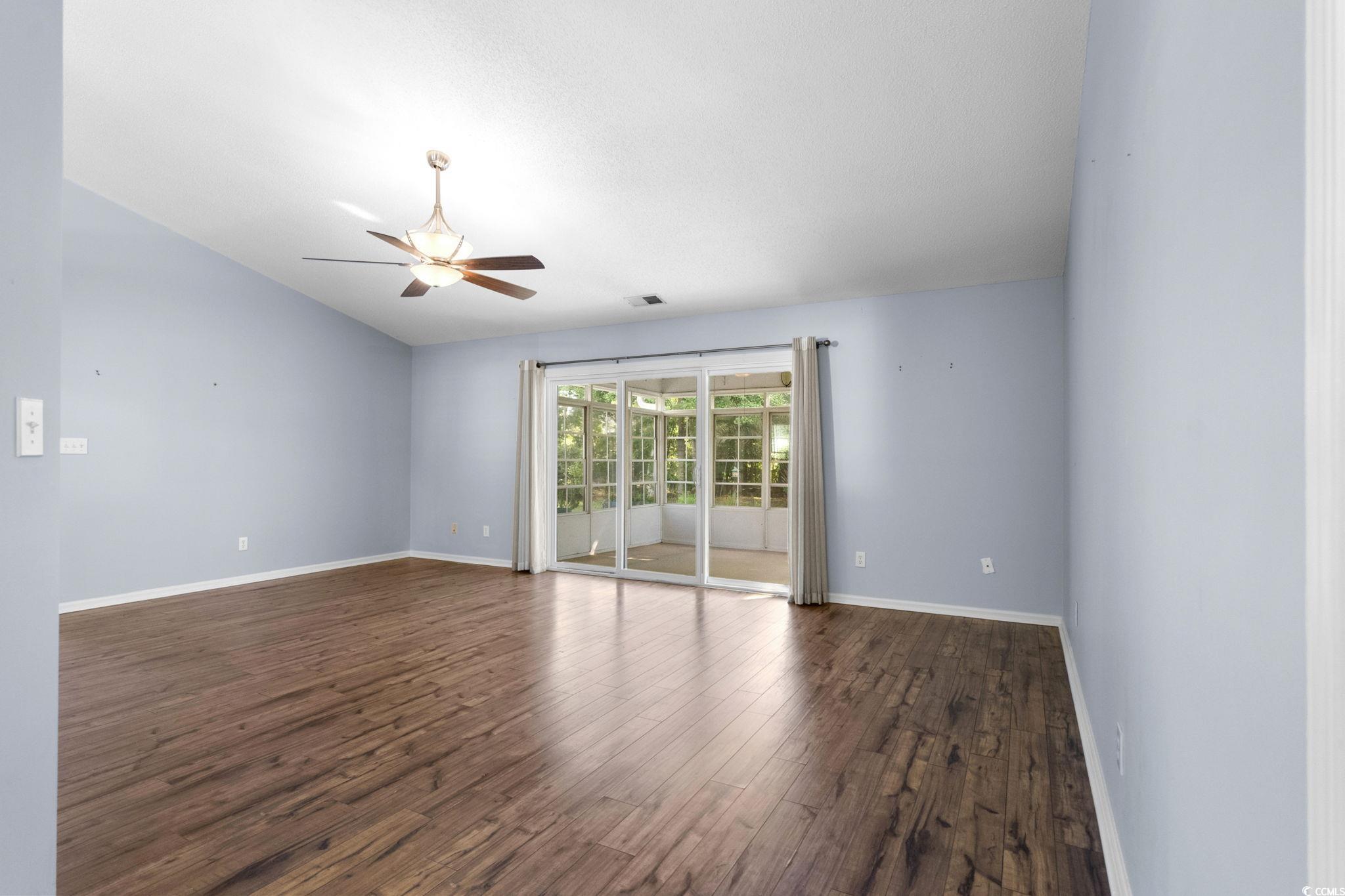 9568 Indigo Club Drive Murrells Inlet, SC 29576 - Photo 4 of 40 Empty room featuring dark wood-type flooring, a ceiling fan, and vaulted ceiling
