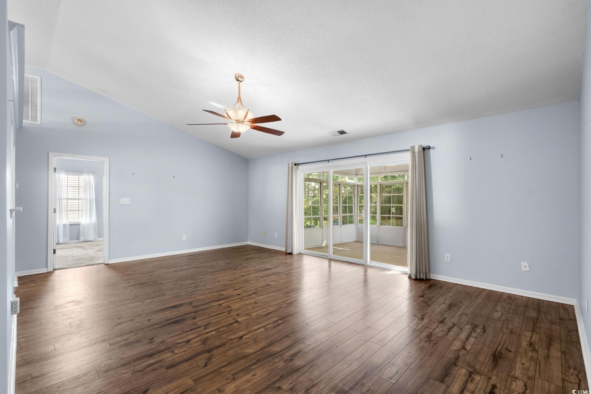 9568 Indigo Club Drive Murrells Inlet, SC 29576 - Photo 5 of 40 Empty room featuring vaulted ceiling, dark wood finished floors, and a ceiling fan