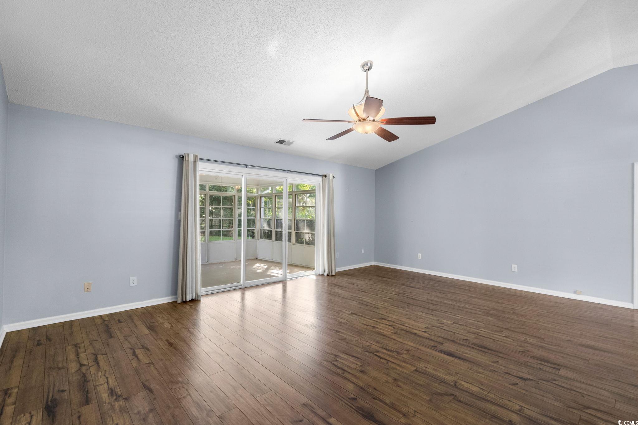 9568 Indigo Club Drive Murrells Inlet, SC 29576 - Photo 6 of 40 Spare room with lofted ceiling, dark wood-style flooring, a ceiling fan, and a textured ceiling