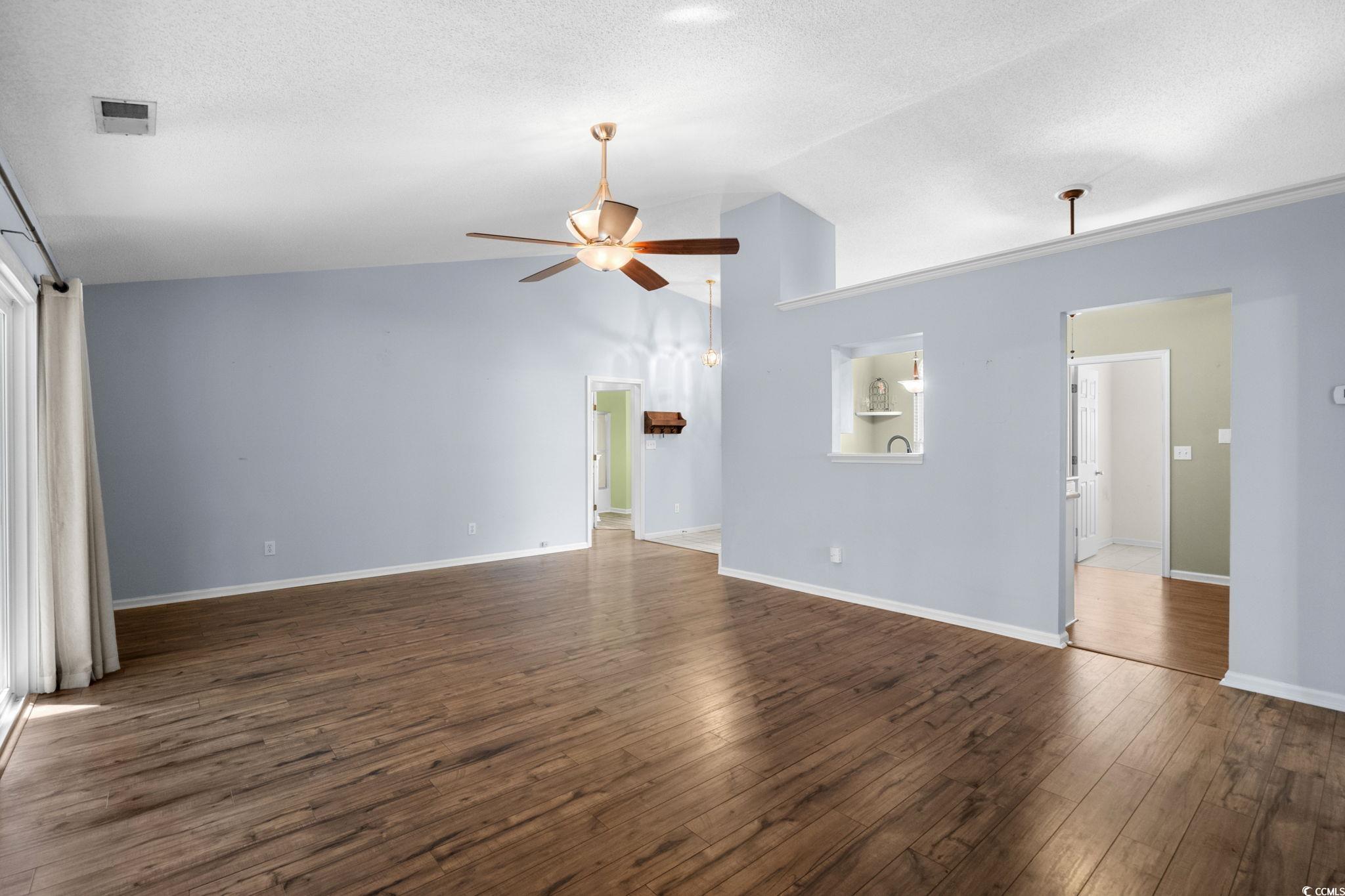 9568 Indigo Club Drive Murrells Inlet, SC 29576 - Photo 7 of 40 Unfurnished living room featuring dark wood-style floors, ceiling fan, a textured ceiling, and high vaulted ceiling