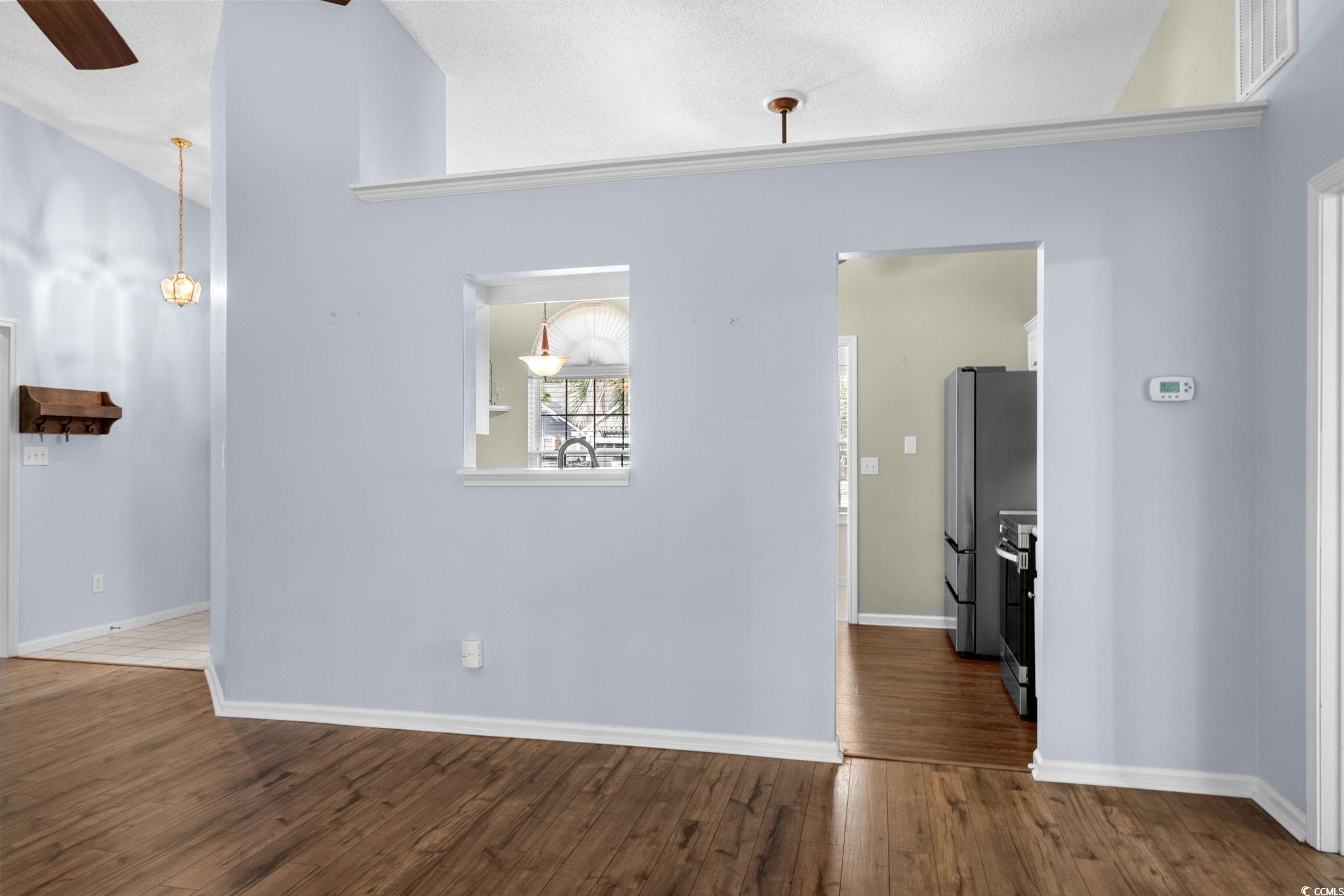 9568 Indigo Club Drive Murrells Inlet, SC 29576 - Photo 10 of 40 Empty room with dark wood finished floors, a ceiling fan, a textured ceiling, and lofted ceiling