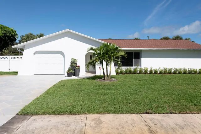 a kitchen with stainless steel appliances granite countertop a stove a sink a refrigerator with a dining table and chairs