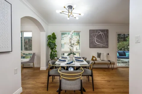 a dining room with furniture a window and wooden floor