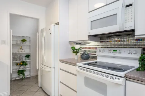 a white stove top oven sitting inside of a kitchen