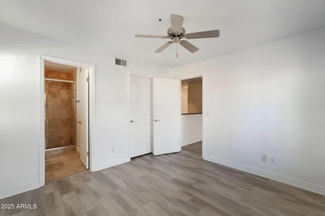 a view of an empty room with window and a kitchen