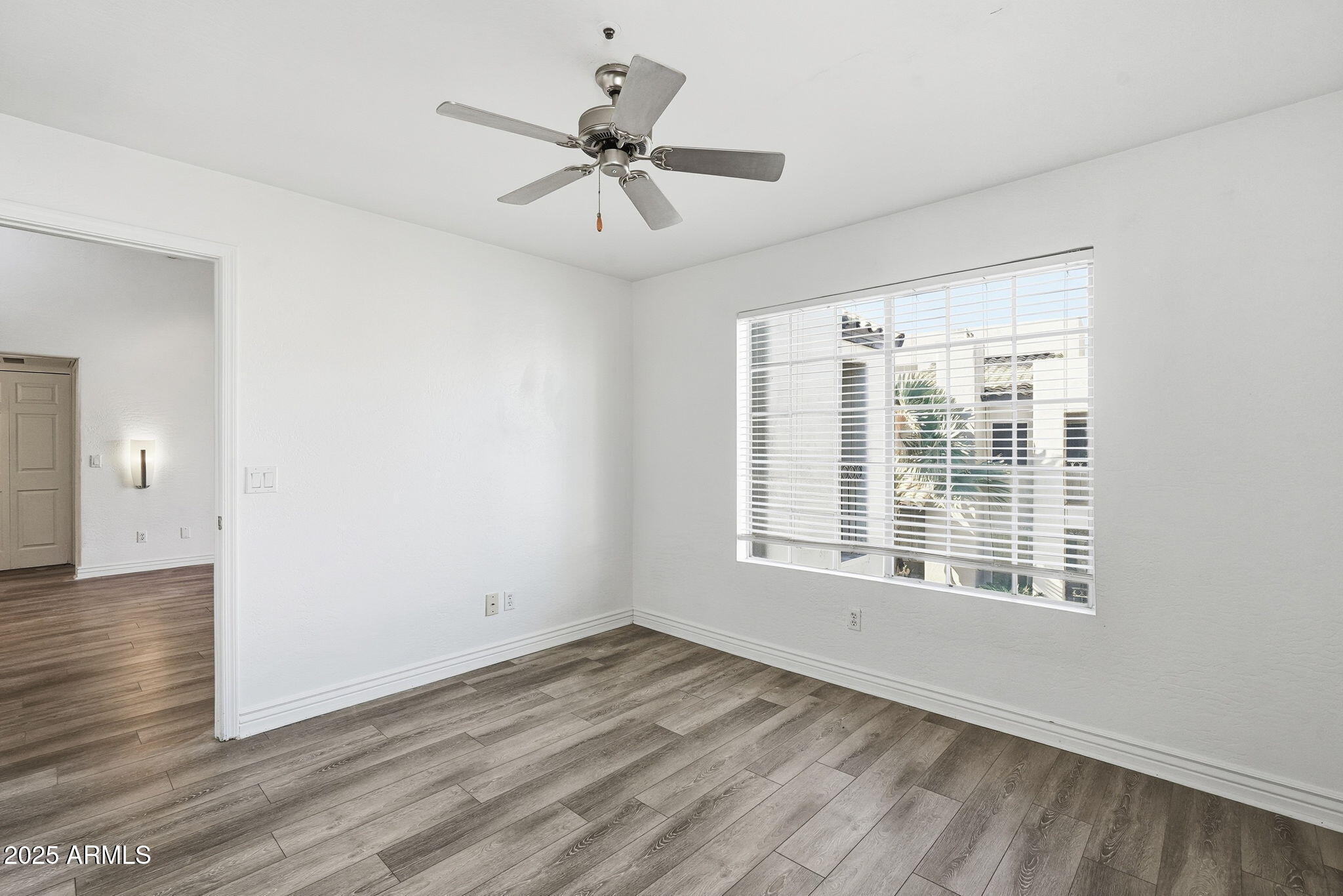 14145 North 92nd Street, Unit 2028 Scottsdale, AZ 85260 - Photo 13 of 24 a view of an empty room with wooden floor and a window