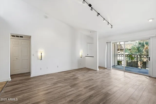 a view of empty room with wooden floor