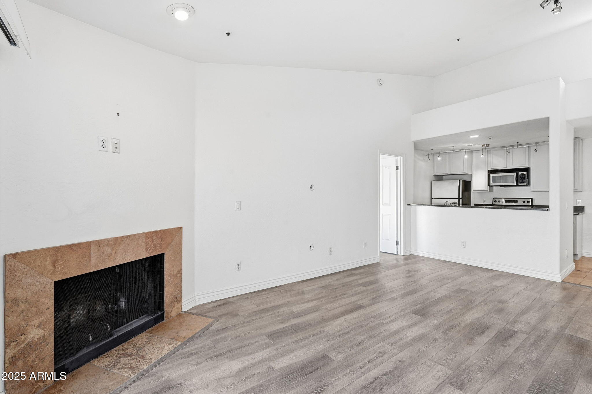 14145 North 92nd Street, Unit 2028 Scottsdale, AZ 85260 - Photo 4 of 24 a view of empty room with kitchen and fireplace
