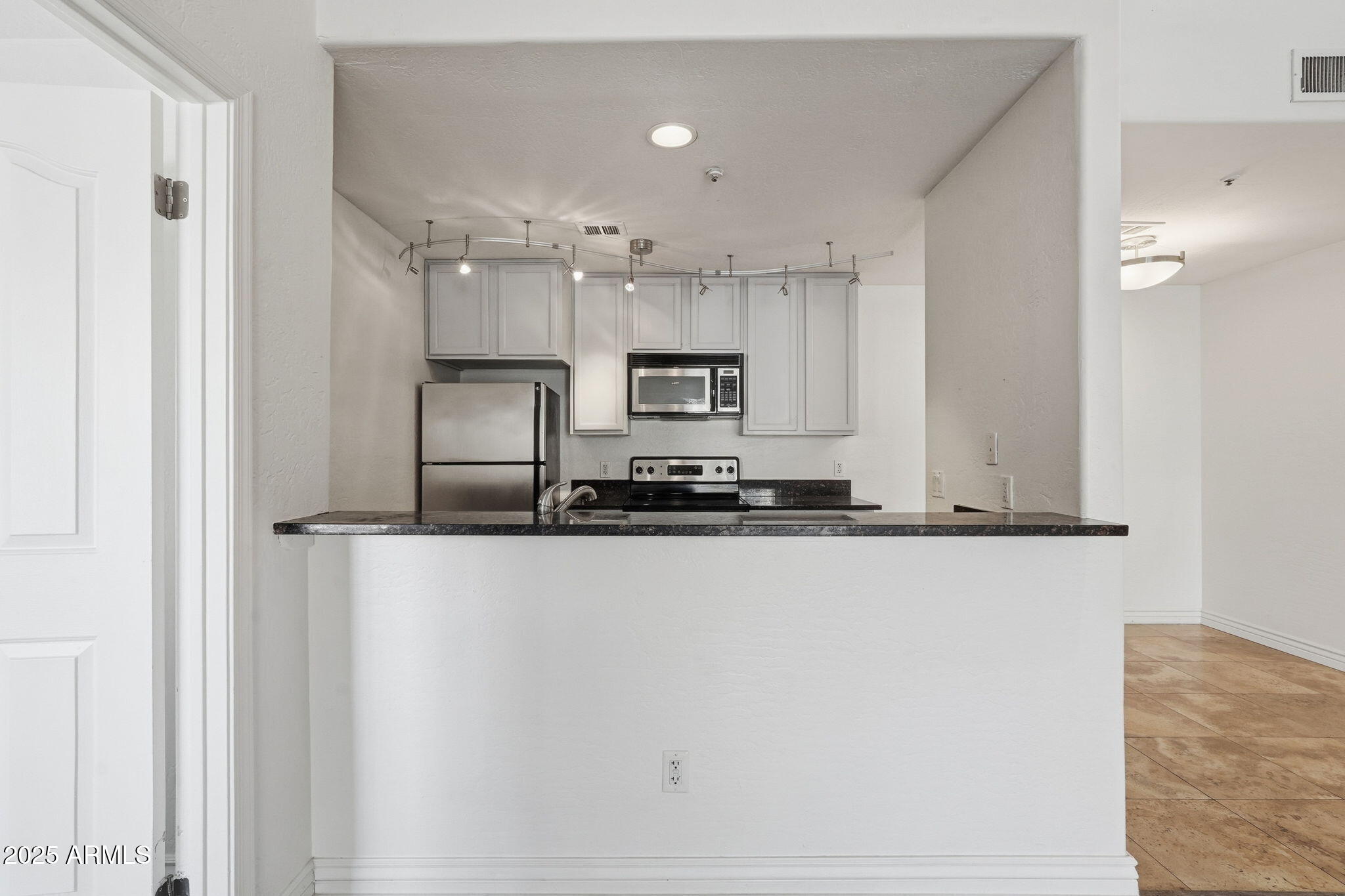 14145 North 92nd Street, Unit 2028 Scottsdale, AZ 85260 - Photo 6 of 24 a large kitchen with granite countertop a refrigerator a sink and a stove