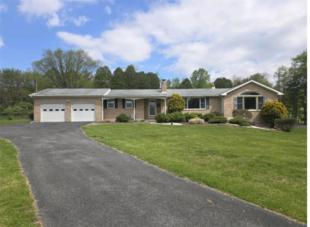 2804 Delps Road Danielsville, PA 18038 - Photo 1 of 1 Manicured lawns frame this classic brick ranch-style home featuring a paved driveway and attached garage.