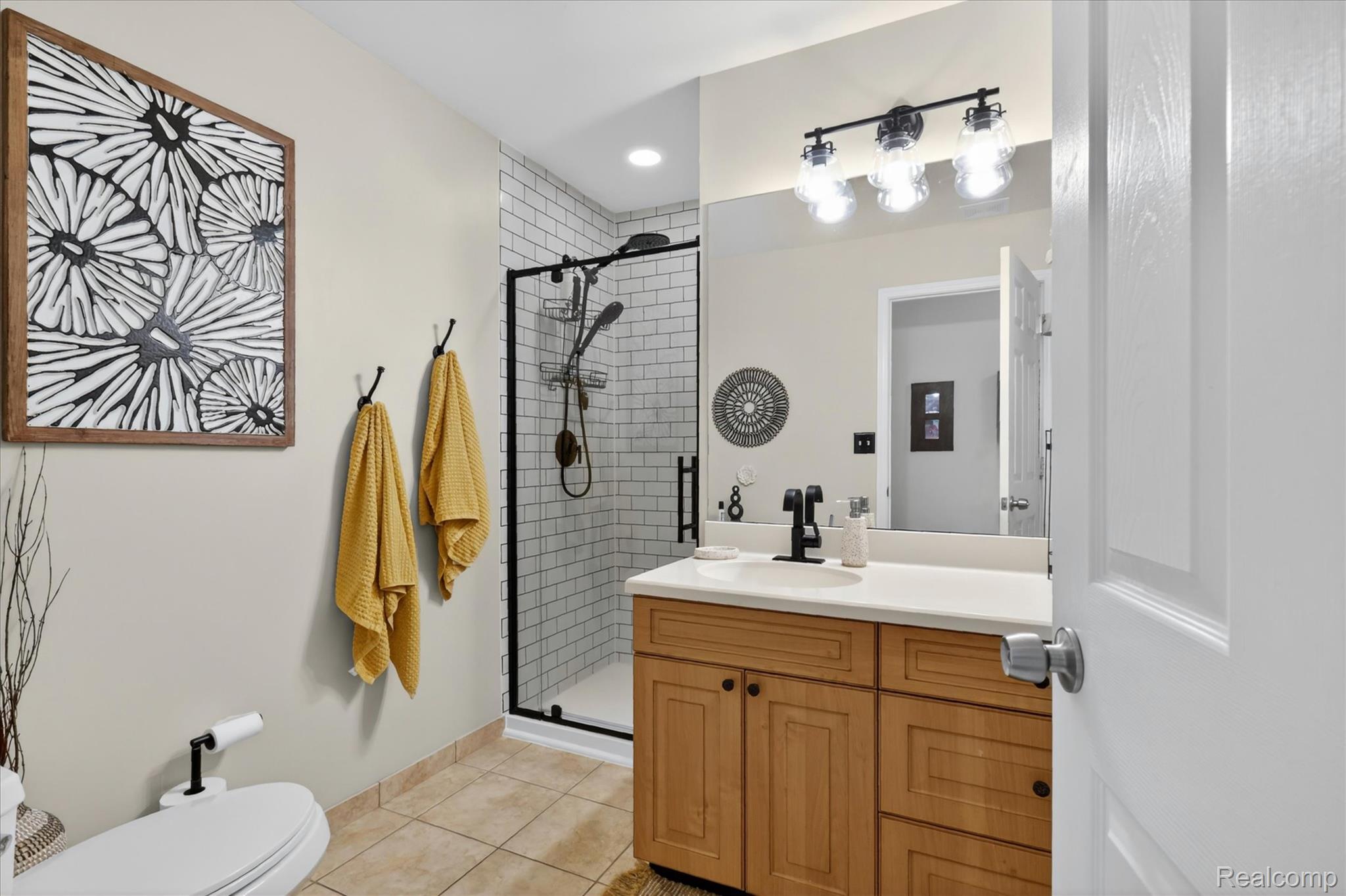 3860 East Commerce Road Commerce Township, MI 48382 - Photo 25 of 72 Bathroom featuring a light wood-finish vanity with a white countertop and undermount sink, black matte faucet, and a large mirror