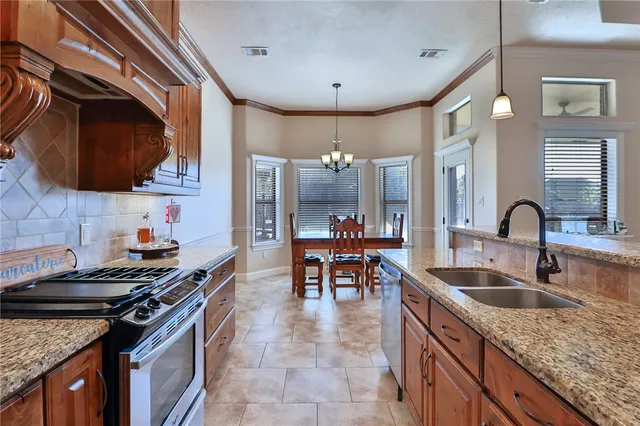 a kitchen with stainless steel appliances granite countertop a stove and a cabinets