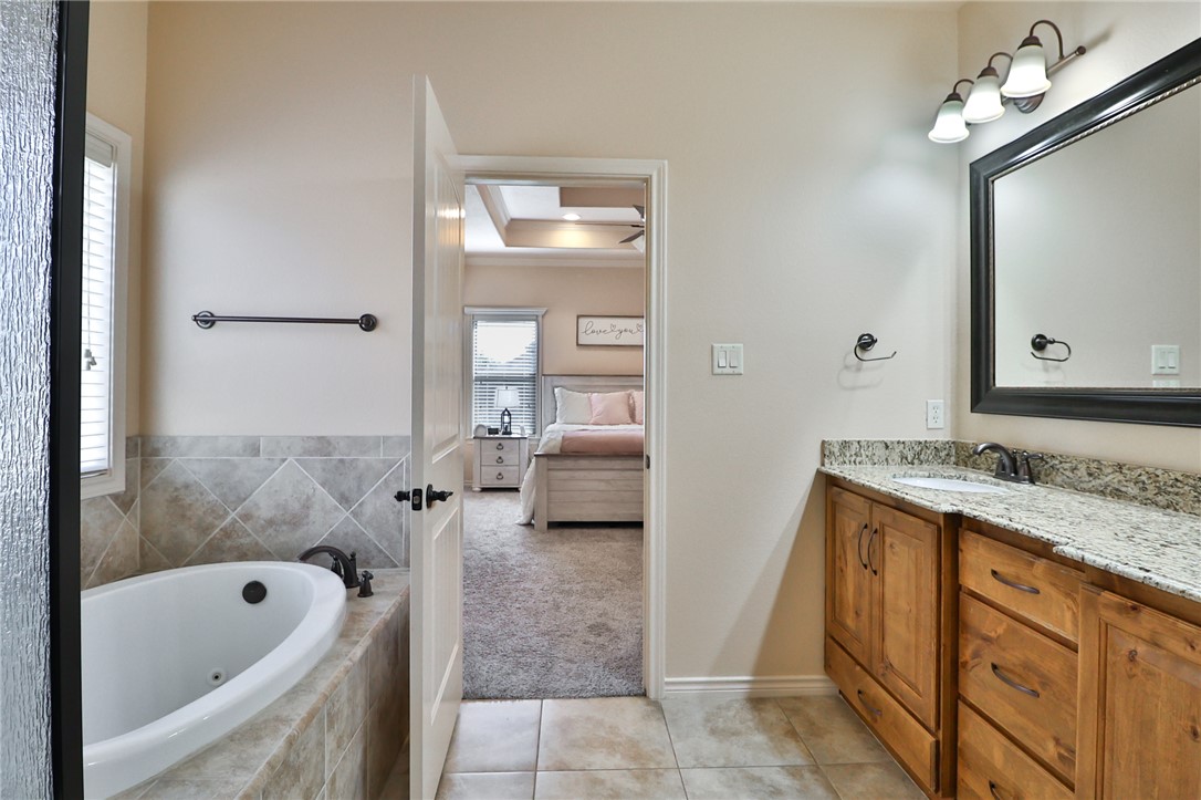 3900 Ambrose Court Bryan, TX 77808 - Photo 19 of 34 a bathroom with a tub sink and mirror