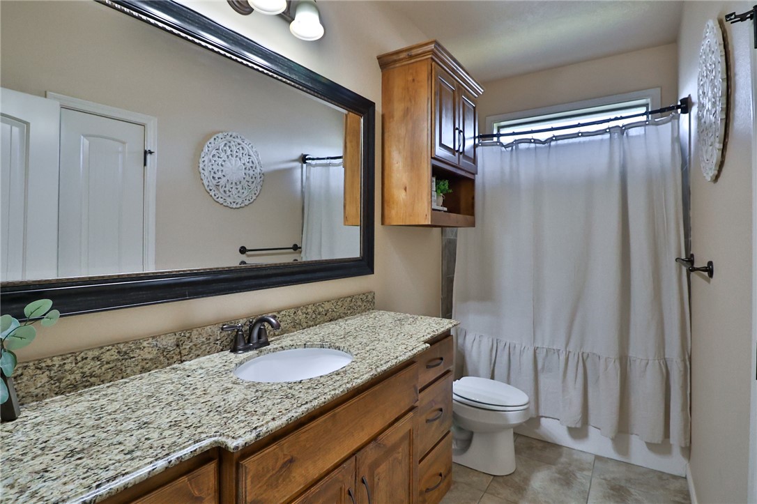 3900 Ambrose Court Bryan, TX 77808 - Photo 25 of 34 a bathroom with a granite countertop sink toilet and shower