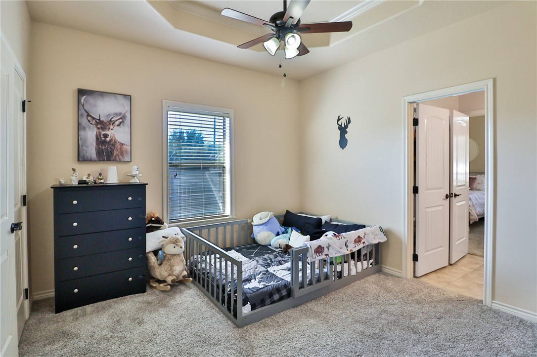 3900 Ambrose Court Bryan, TX 77808 - Photo 27 of 34 a bedroom with a bed and a chandelier
