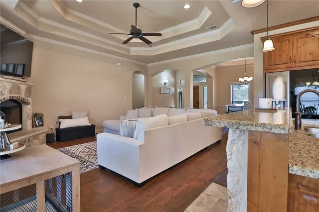 a living room with furniture a chandelier and a flat screen tv