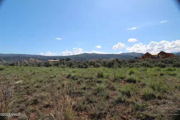 a view of a mountain in the distance in a field