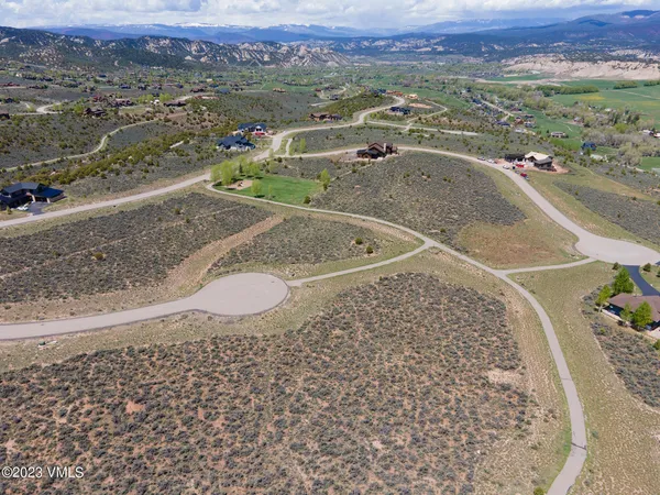 an aerial view of a house with a yard and lake view
