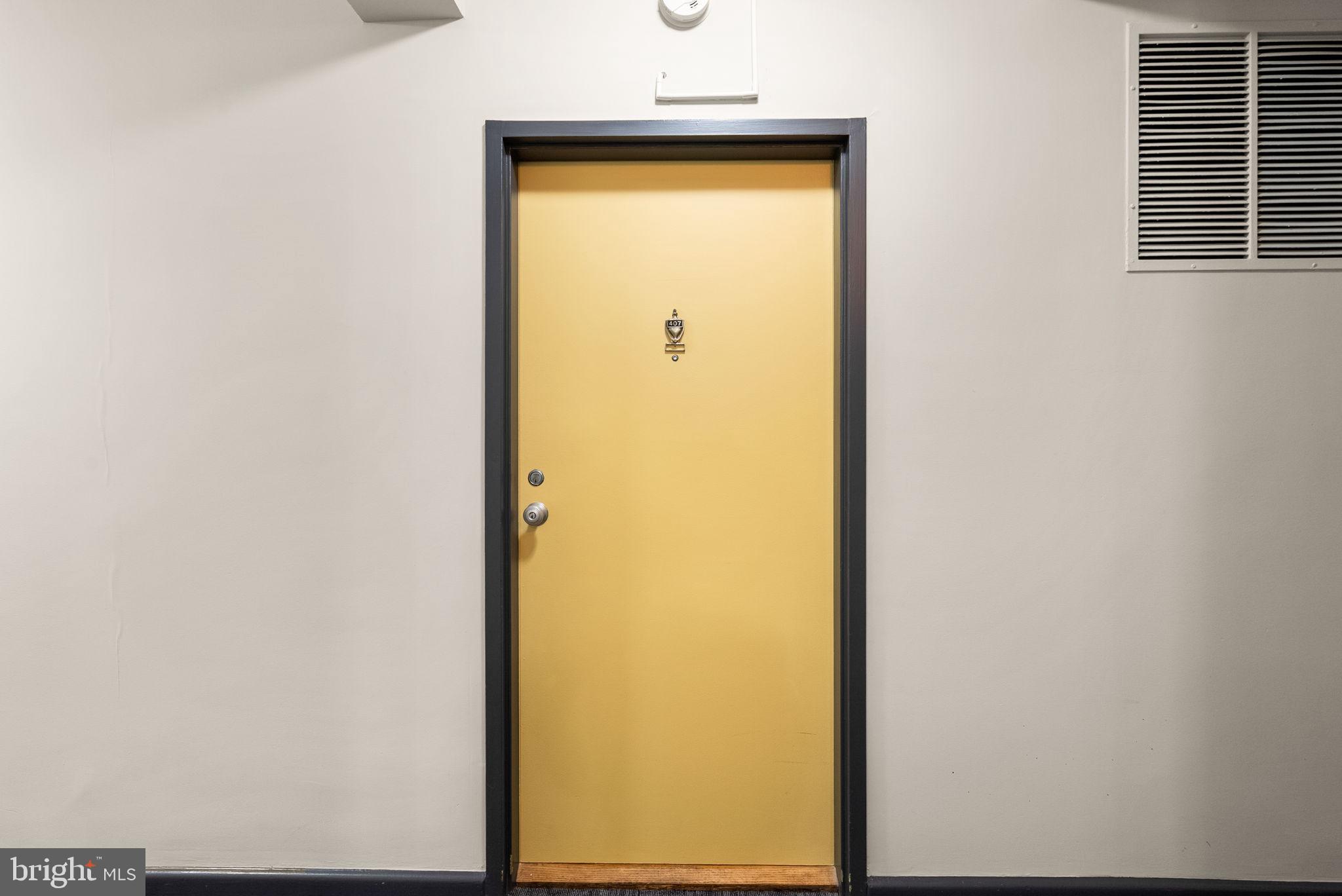 3025 Ontario Road Northwest, Unit 407 Washington, DC 20009 - Photo 6 of 28 Bright yellow door invites curiosity.