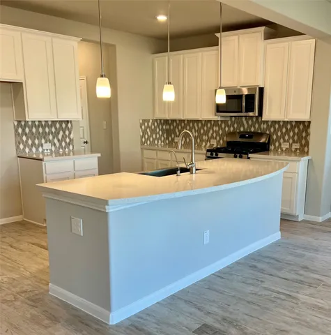 a large kitchen with kitchen island a sink stainless steel appliances and cabinets