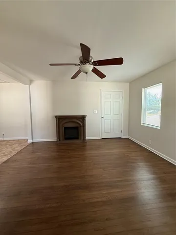a view of empty room with wooden floor and window