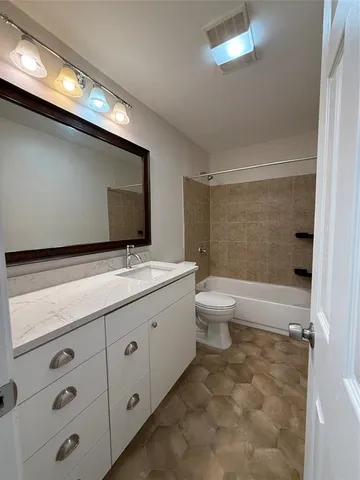 a bathroom with a double vanity sink and a toilet
