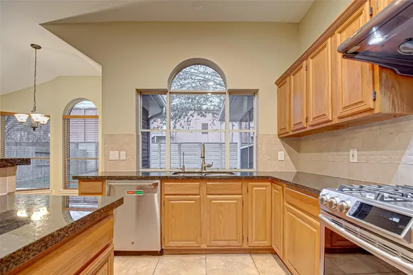 a kitchen with stainless steel appliances granite countertop a stove a sink and a microwave