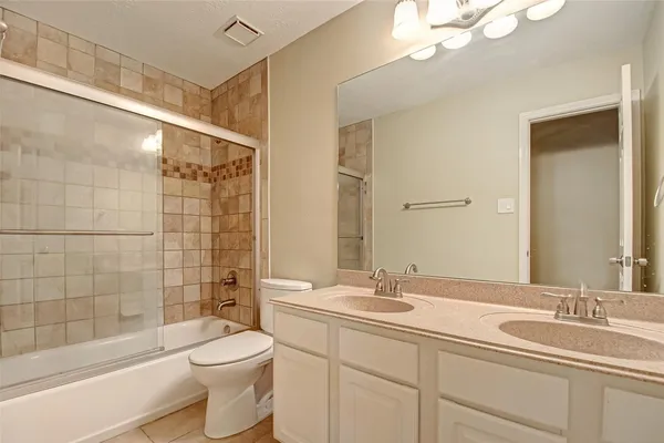 a bathroom with a toilet a sink a mirror a bathtub and shower