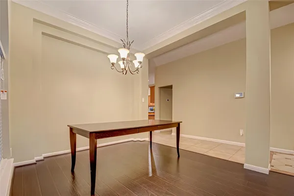 a view of a livingroom with a chandelier wooden floor and a chandelier
