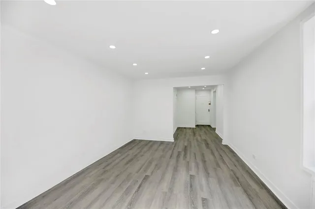 a view of a room with wooden floor and window