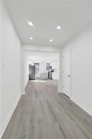 a view of a hallway with wooden floor and a cabinet