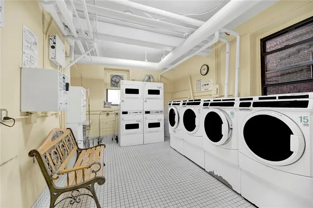 a utility room with stainless steel appliances kitchen island a table chair and a view of living room