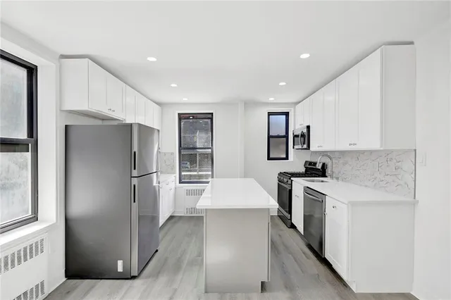 a kitchen with stainless steel appliances granite countertop a refrigerator sink and stove