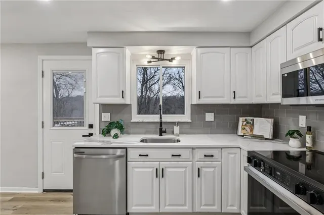 a kitchen with stainless steel appliances granite countertop a sink stove and cabinets