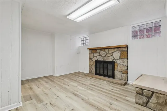 a view of an empty room with a fireplace and a window