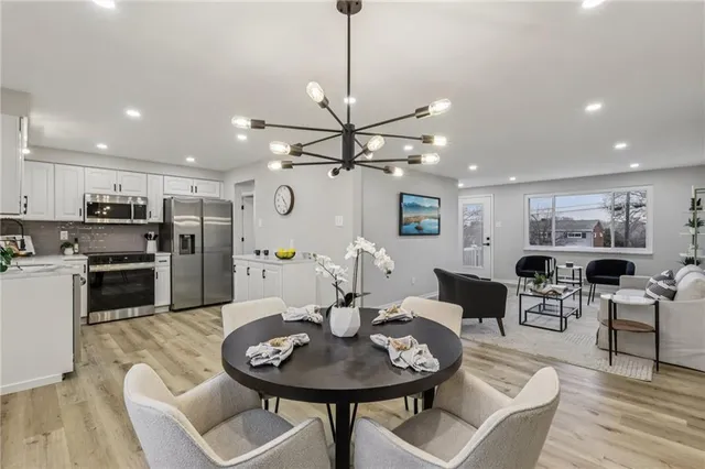 a living room with furniture kitchen view and a chandelier