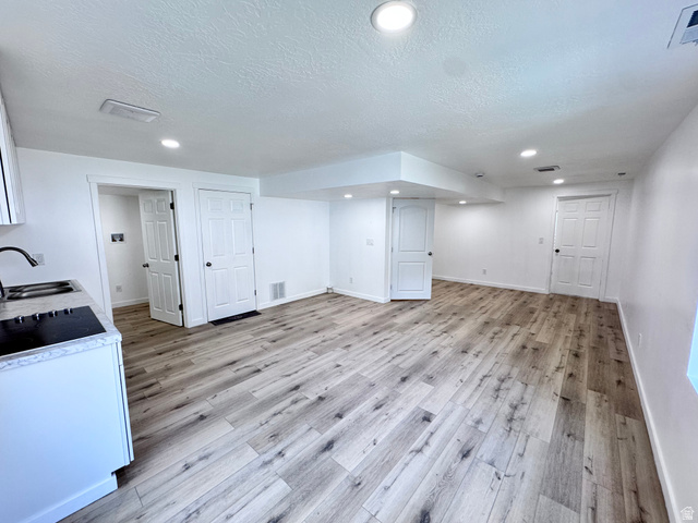 12339 Remy Road, Unit 422 Herriman, UT 84096 - Photo 30 of 36 Finished below grade area with light wood-style flooring, a textured ceiling, and recessed lighting